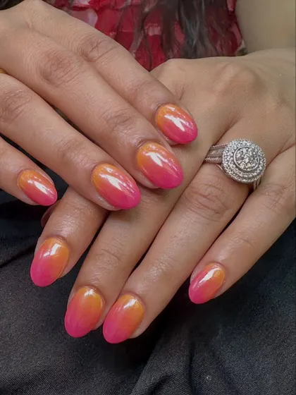 This angle shows how the ombre color shifts from a warm orange near the cuticle to a bright pink at the tip.