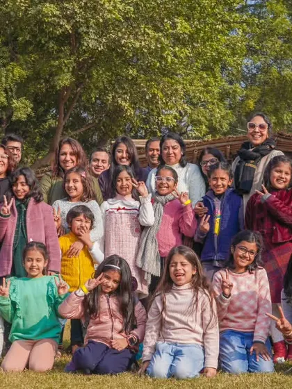 A large, happy group of girls and women posing together after a fun day at the farm.