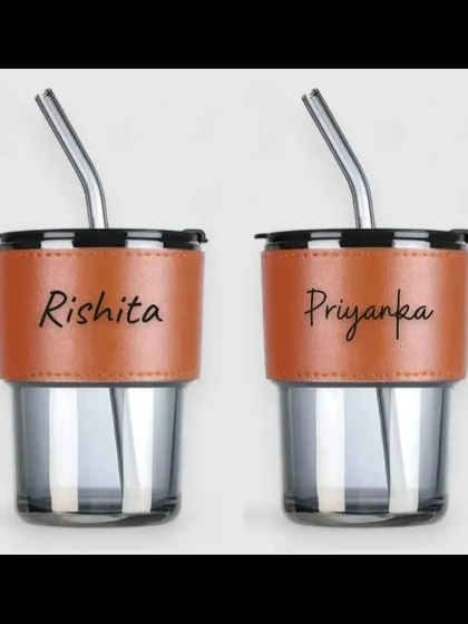 A pair of our personalized glass sippers with names engraved on the brown grip.
