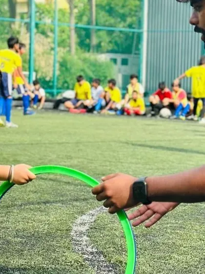 A coach helps a very young player with a coordination drill. Our hands-on approach ensures even the smallest members of our academy feel supported.