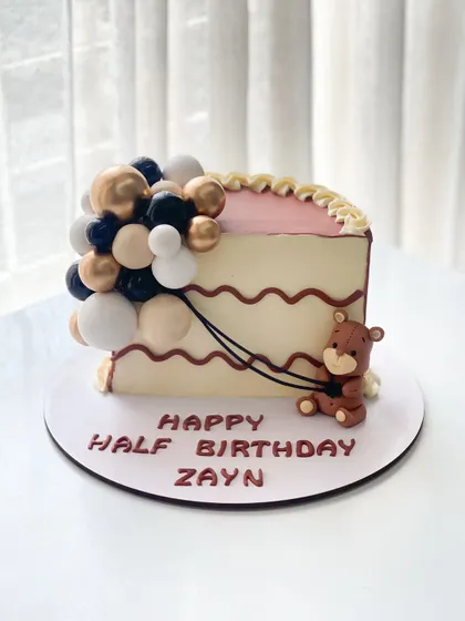 Half birthdays deserve full celebrations! This half-slice cake is decorated with a balloon cascade and a cute teddy bear for Zayn's 6-month milestone.