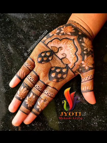 A beautiful Indian mehndi design for the palm, featuring peacock and lotus motifs within a traditional layout.