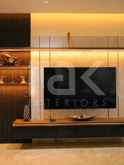 This modern TV unit combines dark fluted panels with light wood and warm backlighting. The design provides both open shelving for decor and closed storage for a clean, organized look.