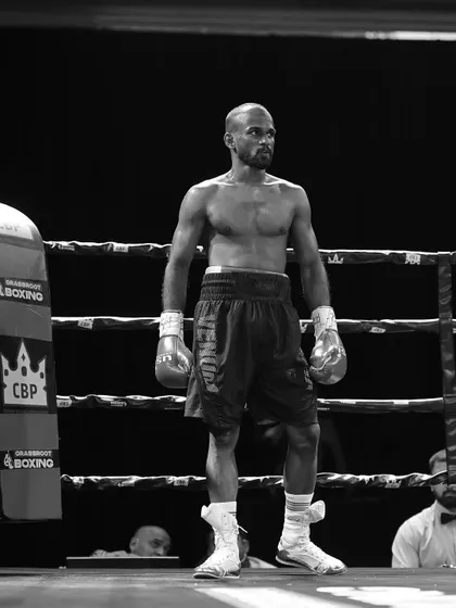 The calm determination of a fighter, standing alone in the ring, ready for the battle ahead.