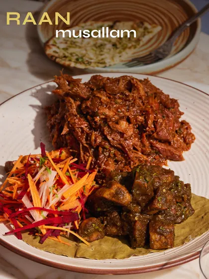 Raan Musallam, slow-cooked and spice-packed, served with a fresh kachumber salad. The meat is so tender it's pulled, ready to be scooped up with naan.