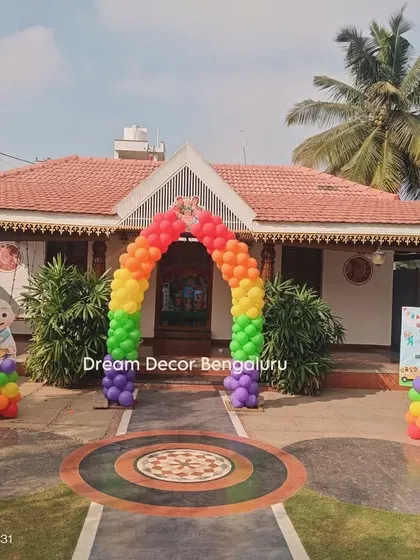 An outdoor view of a Cocomelon party setup at a beautiful traditional house, showing the entrance arch that welcomes guests.