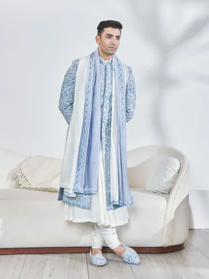 The elegance of the powder blue sherwani in a relaxed pose. The matching embroidered mojris show my commitment to a fully styled, head-to-toe look.