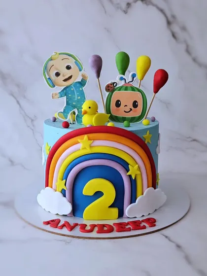 A Cocomelon cake for Anudeep's 2nd birthday. This chocolate mousse cake is bright and colorful, featuring JJ, a rainbow, and other elements from the popular show.