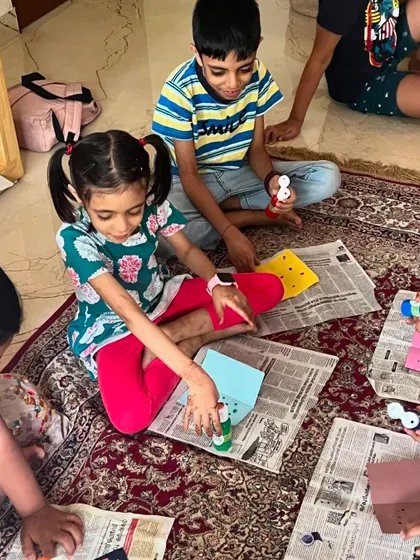 A group of kids working on their insect crafts, using different materials to bring their creations to life.
