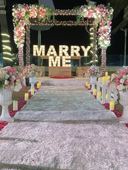 The pathway to forever. A white carpet aisle lined with candles and floral urns leads to the romantic proposal stage.