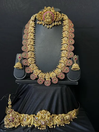 This full kemp stone bridal set is a classic choice. The deep red stones set in an antique gold finish provide a rich, royal look perfect for a muhurtham ceremony.