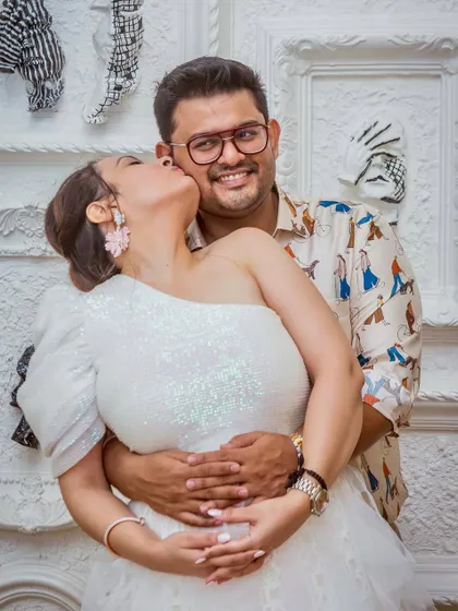 A sweet kiss on the cheek during an engagement party. This candid moment is full of affection and happiness.
