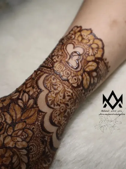 A close up of the heart motif wristband, surrounded by delicate floral and leaf patterns.
