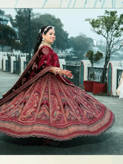 A beautiful shot of the bride twirling in her magnificent red lehenga, with the groom partially visible. The motion and joy in this photo are infectious.