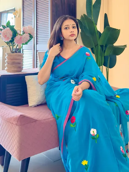 A seated pose on a bench, showing how this saree can be styled for a day out. It's casual, comfortable, and chic.