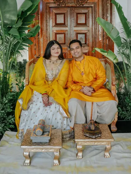 The happy couple glowing in "yellove." We designed this Haldi setting to be both traditional and fresh, with a backdrop of rich greenery that beautifully complemented their yellow outfits.