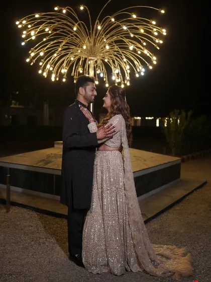 A happy, candid moment between the couple, showcasing their coordinated outfits for the sangeet.