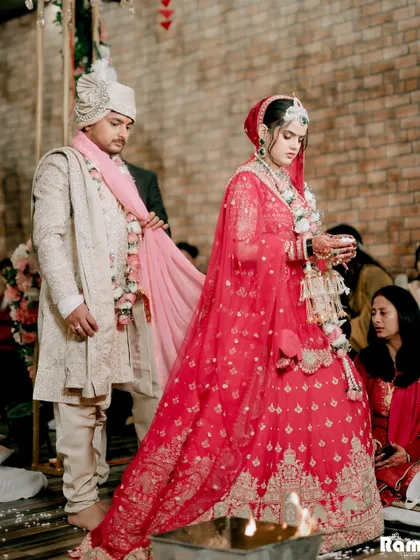 A shot of the couple during the Pheras, a central ritual in a Hindu wedding. The image captures the solemnity and significance of the moment as they take their sacred vows together.