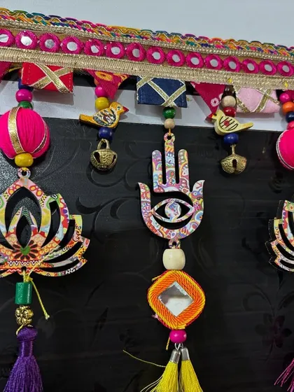 A tight shot of the Hamsa and lotus motifs on the 'Shubh Toran'. The Hamsa hand is a symbol of protection, making this a meaningful piece for any home's entrance.