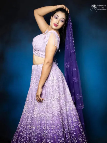 A graceful pose showing off the elegant lehenga and the coordinated purple makeup look.