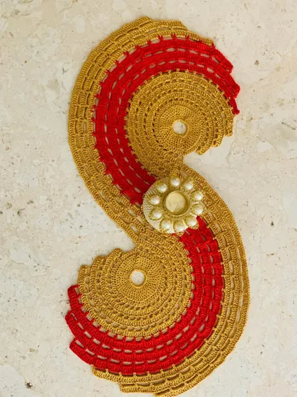 The gold and red spiral runner styled with a decorative candle holder, perfect for a festive setup.