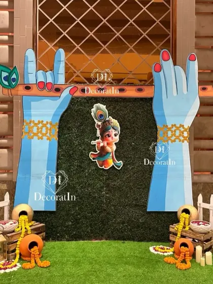 A creative photo booth with large cutouts of hands holding a flute, set against a grass wall.