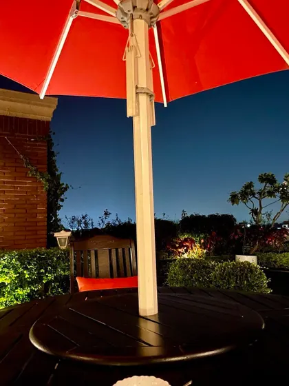 A terrace garden in Vasant Vihar at night. A rooftop garden has more usage than other spaces, acting as an outdoor room, perfect for enjoying a quiet evening under a red umbrella.