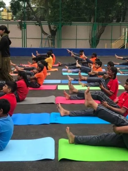 Guiding the children through a seated boat pose variation. Yoga for kids is all about making it fun and accessible.