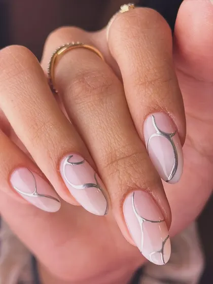 Clean, minimalist, and modern. This design features a milky white base with fine, abstract silver chrome lines, creating a subtle yet sophisticated look on natural-looking almond nails.