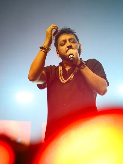 A close-up of a singer performing, with the foreground blurred to draw focus to the artist's passionate expression.