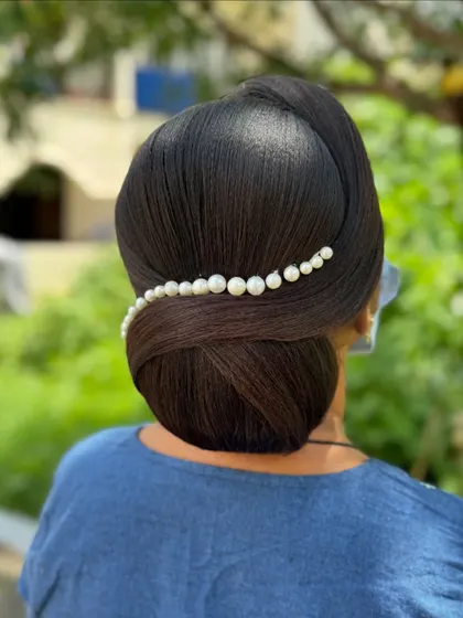 A sleek and modern bun with a simple line of pearls for decoration. This minimalist style is incredibly chic and sophisticated.