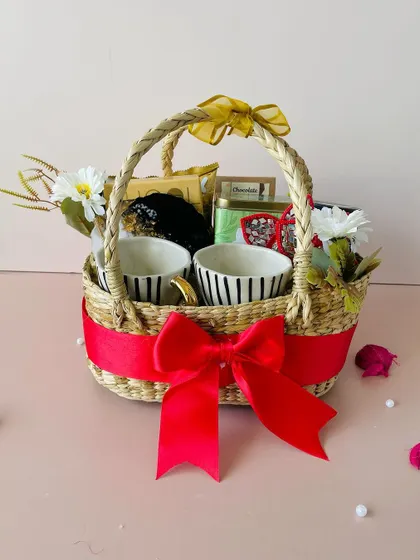 Our oval Kauna basket hamper is perfect for creating a cozy and inviting gift. This one includes two stylish striped ceramic mugs, making it a wonderful present.