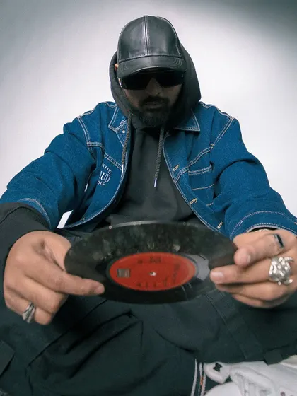 A direct, confident pose holding a classic 45 record. My style is a tribute to the foundations of hip hop.