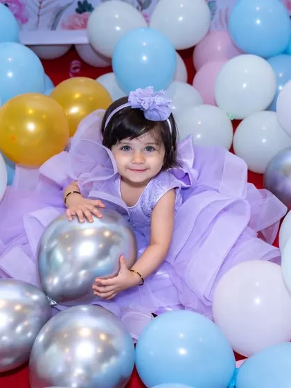 Swimming in a sea of balloons. This playful shot perfectly captures the fun and magic of being a kid at a birthday party.