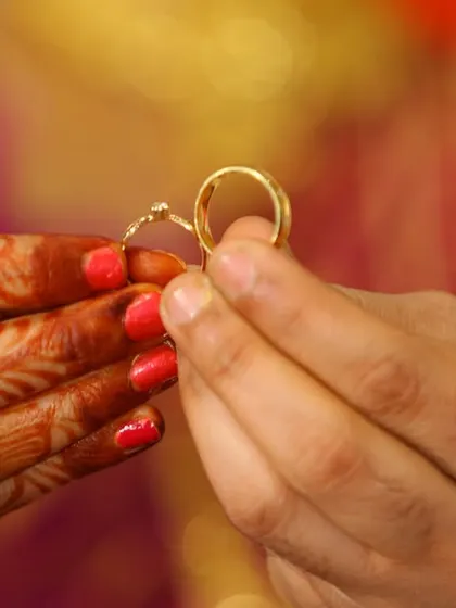 A close-up of hands holding a pair of wedding rings, a simple and symbolic shot.