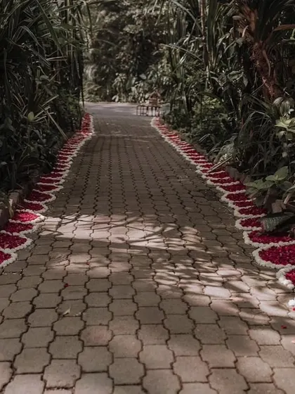 A pathway lined with flower petals, leading guests through a lush garden to the ceremony area. It's a simple detail that makes a big impact.