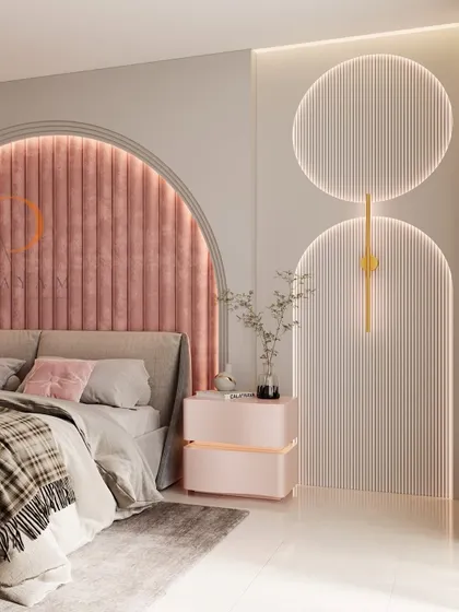A modern bedroom design featuring a striking arched headboard with pink velvet channel tufting. The space is enhanced by custom backlit wall panels and a matching bedside table, creating a soft, luxurious, and contemporary ambiance.