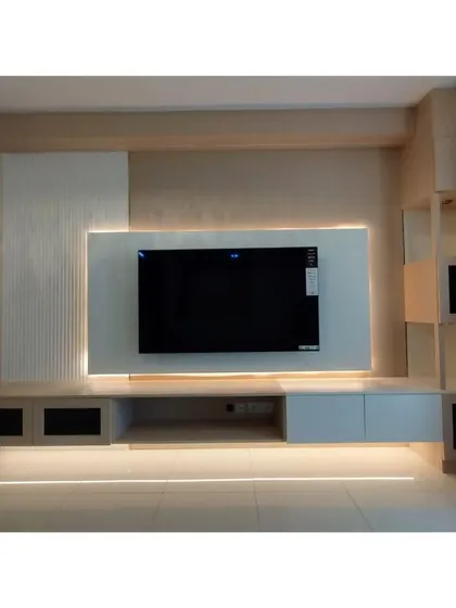 The floating design of the TV console and the vertical display shelves make the living space feel larger and more open.