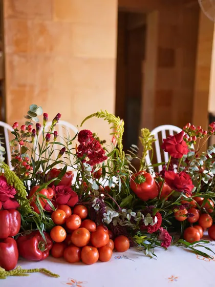 Another beautiful and rustic centerpiece from the Revival Lunch, combining red flowers with fresh tomatoes and bell peppers.