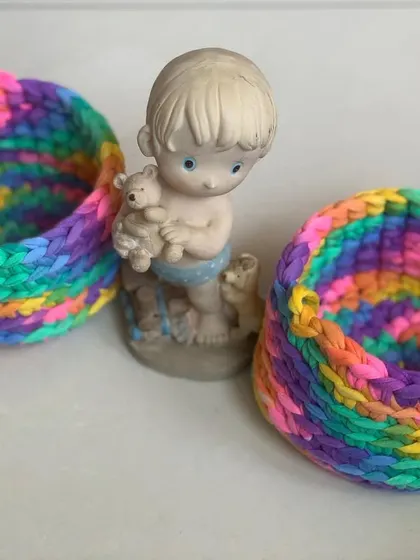 These colorful baskets are a must-have for any room. Here they are styled with a small figurine, showing their decorative potential.