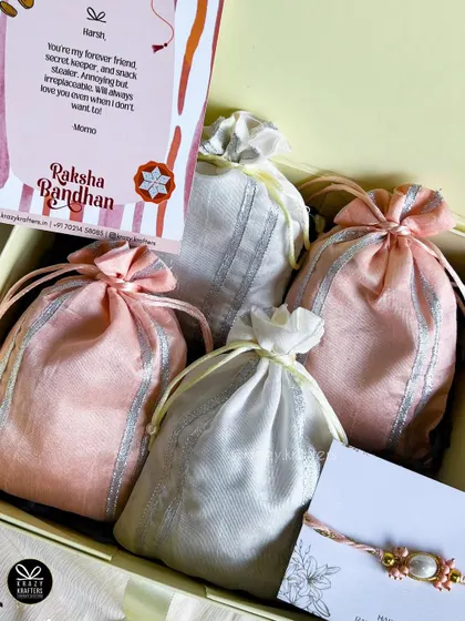 Our 'Rakhi Saga' hamper offers a luxe feel with beautiful potlis and a personalized card, all packed elegantly.