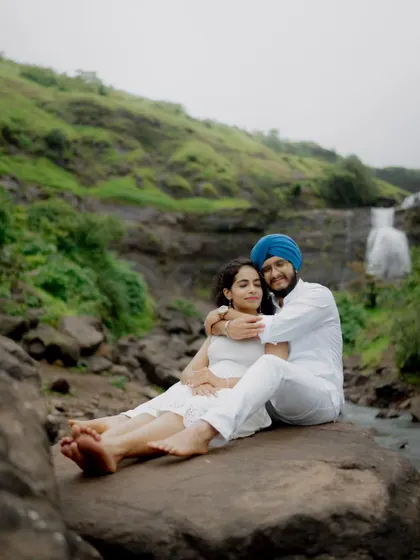 A peaceful moment shared by the couple, sitting on a rock amidst the natural beauty of their pre-wedding shoot location.
