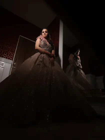 A bride’s radiance captured in a single moment. This dramatic, low-key portrait in a stunning gown creates a sense of mystery and elegance.