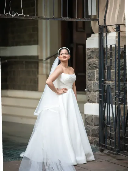 A stunning full-length portrait of the bride outside a classic Mumbai church. Her elegant pose and beautiful dress make for a timeless wedding photo.