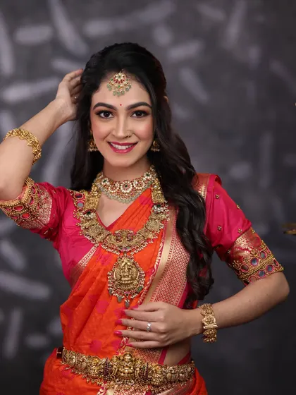A happy bride ready for her big day. This antique gold set features beautiful goddess motifs, a matching waist belt, and maang tikka for a complete, traditional look.