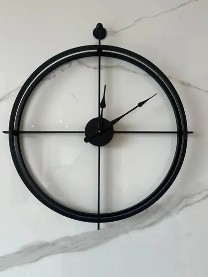 A classic minimalist design, this large 24-inch metal wall clock features a simple double-ring frame in an antique black finish. Its clean lines and open face make it a versatile piece that complements any decor style, from modern to industrial.
