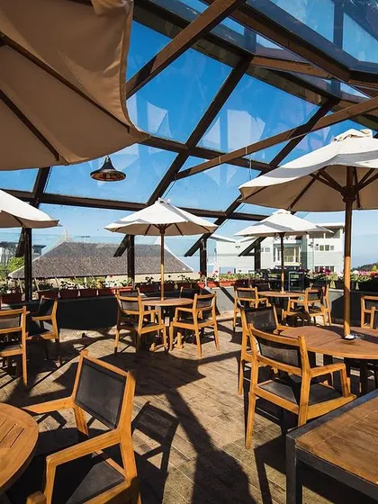 A duplicate image of the Finch Ecofarms restaurant, emphasizing the bright, airy atmosphere created by the skylight roof and open-sided design.