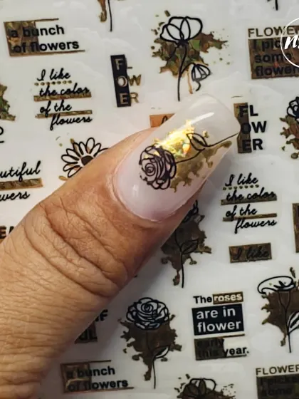 A student experimenting with nail stickers and gold foil. This is a great way to create intricate designs quickly and beautifully.