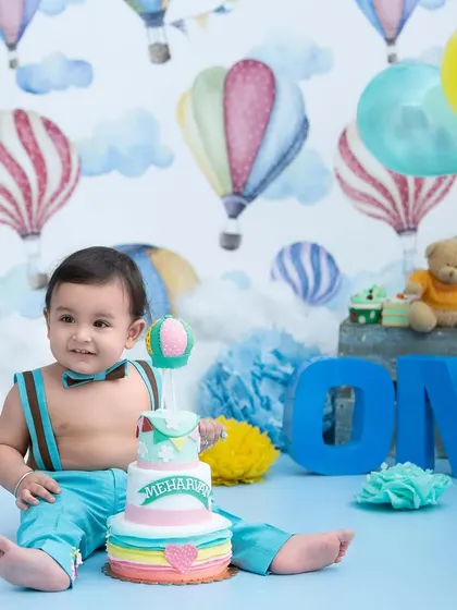 Up, up, and away. This hot air balloon themed first birthday shoot uses a colorful backdrop and props to create a light and cheerful atmosphere.