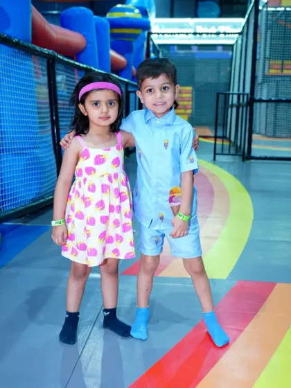 Two stylishly dressed friends posing together during a pastel-themed birthday party.